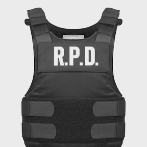 May include: Black tactical vest with the white letters "R.P.D." across the chest. The vest has adjustable straps and closures. The vest is designed to provide protection and is made of durable materials.