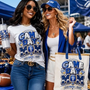 May include: A white t-shirt and a white tote bag, both featuring blue and gold graphics with the text "GAME DAY MOM" and "LOUD PROUD & READY". The t-shirt has a football icon, while the tote bag includes a gold glitter trim and a blue base.