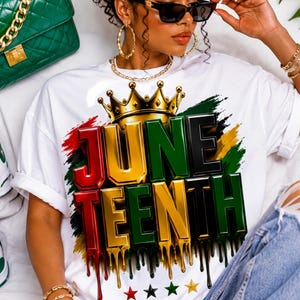 Könnte beinhalten: Ein weißes T-Shirt mit einem Grafikdesign, das den Text JUNETEENTH in einer metallischen 3D-Schrift in Rot, Gold und Grün zeigt. Über dem Text befindet sich eine goldene Krone und darunter vier kleine Sterne in Rot, Schwarz, Grün und Gold.