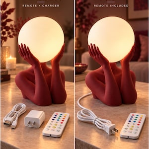 Puede incluir: Una l&aacute;mpara de mesa roja con una figura cuyas manos sostienen una esfera luminosa. La versi&oacute;n inal&aacute;mbrica incluye un cargador USB y un mando. La versi&oacute;n con enchufe incluye un cable de alimentaci&oacute;n y un mando a distancia.