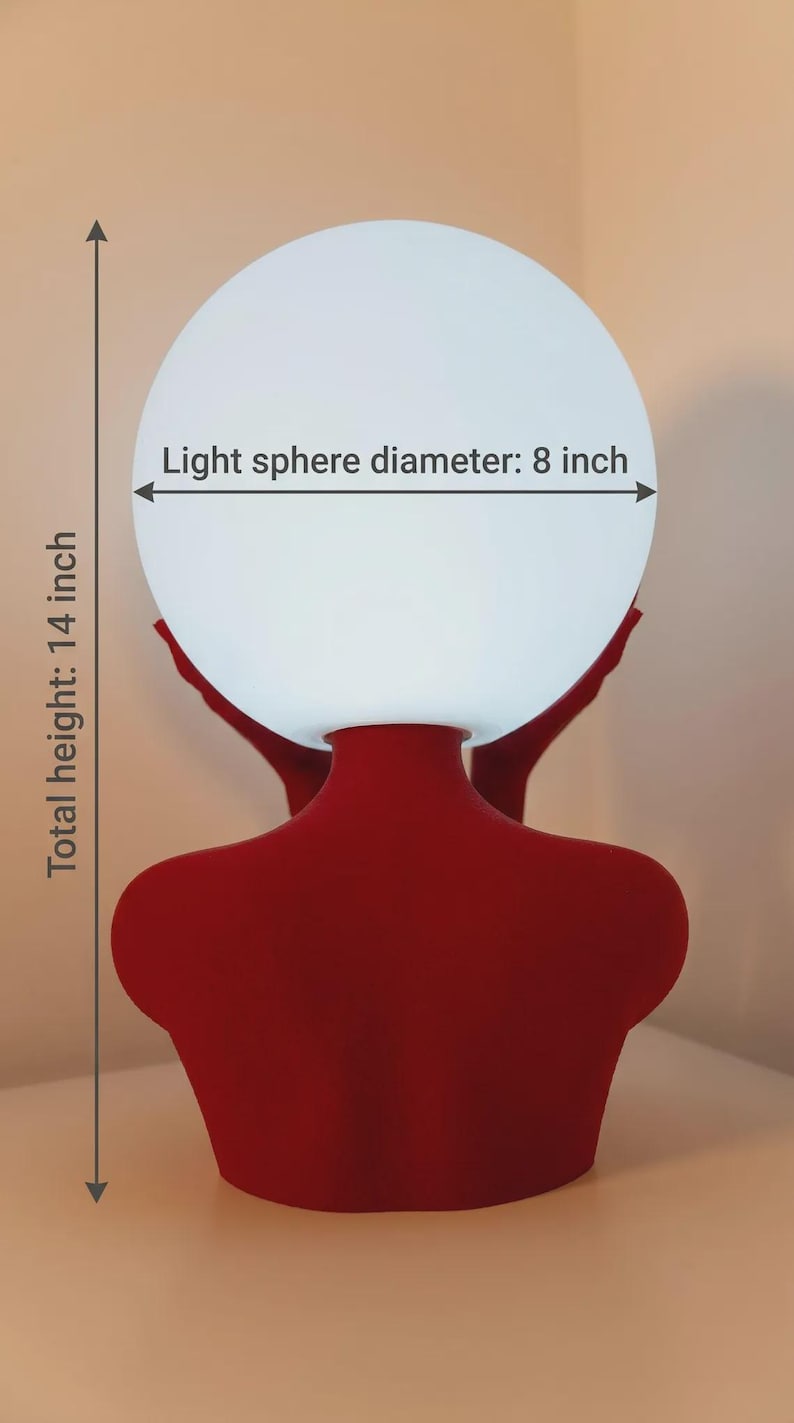 Puede incluir: Una base de l&aacute;mpara con forma de busto rojo que sostiene un globo de luz esf&eacute;rico blanco. El texto en la imagen indica un di&aacute;metro de esfera de luz de 8 pulgadas y una altura total de 14 pulgadas. La l&aacute;mpara tiene un acabado rojo mate.