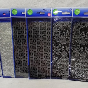 Peut inclure: Plusieurs planches d'autocollants Starform dans des emballages transparents avec des bordures bleues. Les motifs comprennent des motifs floraux, des grilles géométriques et des illustrations d'oiseaux et de manèges.