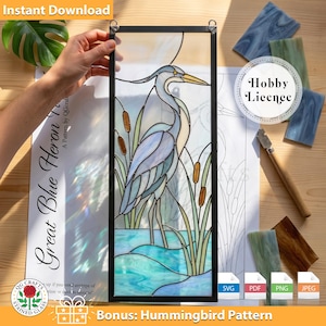 May include: A stained glass panel featuring a Great Blue Heron in shades of blue, gray, and yellow, set against a water and cattail background. The panel is framed in black and includes the text "Great Blue Heron" and "Instant Download".