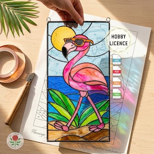 Puede incluir: Vidriera de un flamenco con gafas de sol en una escena de playa soleada. La obra de arte incluye el texto "HOBBY LICENCE" y "OG CRAFTS STAINED GLASS".