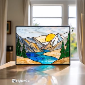 Peut inclure: Panneau en vitrail repr&eacute;sentant un paysage de montagne avec une rivi&egrave;re, des arbres et un coucher de soleil. L'&oelig;uvre d'art pr&eacute;sente un cadre noir et des couleurs vives, dont le bleu, le vert, le jaune et le marron. Le texte "By: QGCrafts" est visible.