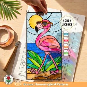 May include: A stained glass panel featuring a pink flamingo wearing sunglasses, set against a blue sky and water background. The artwork includes a yellow sun and green foliage. The panel is labeled "Hobby Licence" and includes file type icons. The text "Bonus: Hummingbird Pattern" is also visible.
