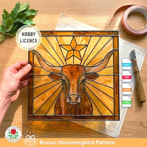 Könnte beinhalten: Buntglasfenster mit einem Longhorn-Rind mit Sternmuster. Das Kunstwerk ist in Bernstein- und Brauntönen gehalten, mit einem Hobby Licence-Etikett. Das Panel ist quadratisch und hat einen Metallrahmen. SVG-, PDF-, JPEG- und PNG-Symbole.