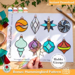 May include: A digital pattern sheet titled Christmas Baubles featuring illustrations of eight stained glass ornaments in various shapes and colors, including yellow, blue, purple, and green, with a hobby license and bonus hummingbird pattern.