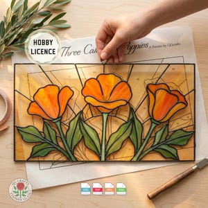 May include: Stained glass panel featuring three orange poppies with green leaves. The panel has a black border and is set against a light yellow background. The words "HOBBY LICENCE" and "Three Cah Poppies" are visible.