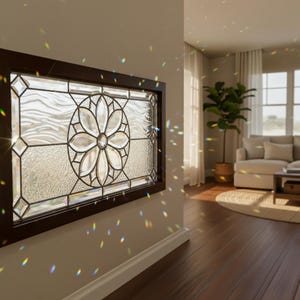 Puede incluir: Una ventana rectangular de vidrieras con un marco marrón oscuro. La ventana presenta un diseño floral central y patrones geométricos. El vidrio tiene una apariencia texturizada y la ventana está montada en una pared de color claro.