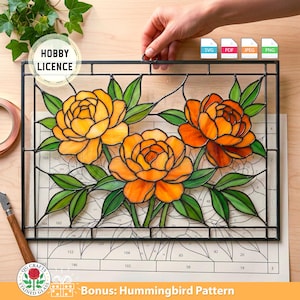 Op de afbeelding: Gebrandschilderd glaspaneel met drie oranje en gele pioenrozen en groene bladeren, omlijst in zwart. Het paneel wordt door een hand vastgehouden. Bevat de tekst "HOBBY LICENCE" en "Bonus: Hummingbird Pattern".