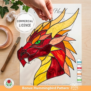 Op de afbeelding: Een glas-in-lood drakenhoofdpatroon in rood, oranje en gele tinten, met groene ogen en een gedetailleerd ontwerp. De afbeelding bevat de tekst "COMMERCIAL LICENCE" en "Bonus: Hummingbird Pattern".