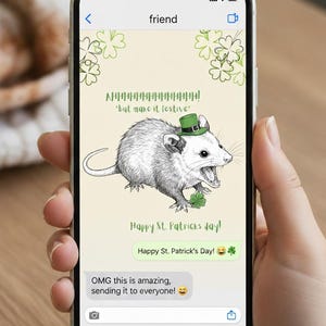 以下が含まれることがあります： スマートフォン画面には、聖パトリックの日のテーマのイラストが表示されています。緑の帽子をかぶり、四つ葉のクローバーを持っている漫画のオポッサムが特徴です。「Happy St. Patrick's Day!」とメッセージバブルが含まれています。