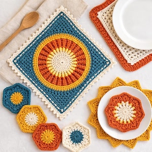 May include: A collection of colorful, handmade crochet items. The image features a large square trivet with a circular design in shades of blue, orange, yellow, and cream. Several hexagonal coasters and a star-shaped trivet are also visible.
