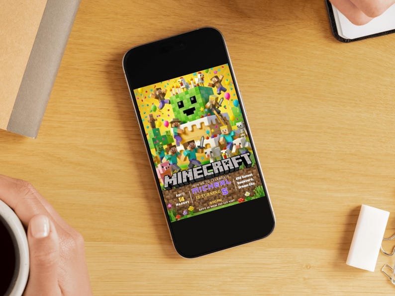 May include: A smartphone displays a colorful Minecraft-themed birthday party invitation. The design features pixelated characters, a green Creeper, and the word "Minecraft." The invitation includes details like the date, time, and location for the party.