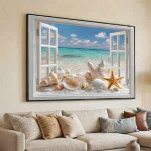 May include: A framed wall art piece depicting a beach scene viewed through an open window. The artwork features various seashells, a starfish, and sand, with a turquoise ocean and blue sky visible through the window.