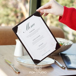 May include: A rectangular menu holder with dark brown textured corners and a white insert featuring the word Menu, sections for Starters, Main Course, and Dessert, and the names Margarita & Benjamin printed in a black serif and script font.