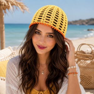 May include: A bright yellow crochet beanie featuring an openwork pattern and a decorative orange beaded trim along the bottom edge. The hat is constructed with a lightweight yarn, showcasing a textured, airy design suitable for warm weather.