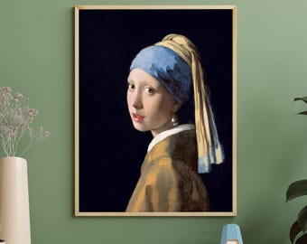 Op de afbeelding: Ingelijste print van het beroemde schilderij "Meisje met de parel". Het kunstwerk toont een jonge vrouw met een blauw en gele hoofddoek, een parel oorbellen en een donkere achtergrond. De lijst is licht van kleur.