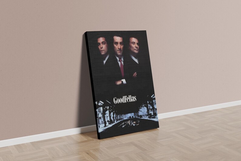 May include: A canvas print featuring the movie poster for "Goodfellas." The artwork showcases three men in suits against a dark background. The title "Goodfellas" is displayed at the bottom, with a city scene illustration.