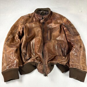 K&ouml;nnte beinhalten: Braune Leder-Bomberjacke mit geripptem Kragen, B&uuml;ndchen und Saum. Die Jacke hat einen Rei&szlig;verschluss, mehrere Taschen und ein Used-Finish. Die Ma&szlig;e der Jacke sind auf dem Bild nicht sichtbar.