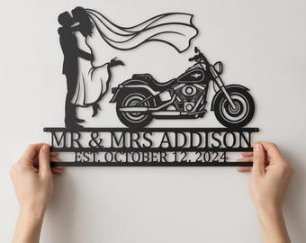 May include: A black metal wall sign featuring a silhouette of a couple kissing next to a motorcycle. The text reads MR & MRS ADDISON and EST. OCTOBER 12, 2024. The design includes a flowing veil extending from the figure in the dress toward the bike.