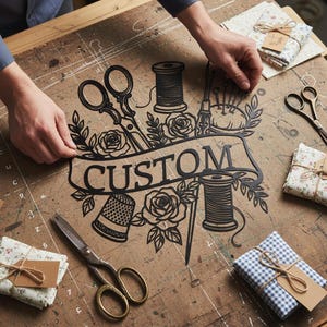 Könnte beinhalten: Ein schwarzes Metallschild mit dem Wort "CUSTOM" und Illustrationen zum Thema Nähen, darunter Scheren, Garnrollen und Rosen. Das Schild ist von Stoffbündeln und Scheren auf einer Holzoberfläche umgeben.