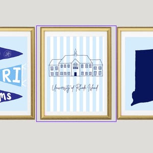 May include: Three framed prints with gold frames. The left print has blue pennants with "Go URI Rams" text. The center print shows a building with "University of Rhode Island" text. The right print is a blue outline of Rhode Island.