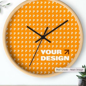 Op de afbeelding: Ronde wandklok met een licht houten frame. De wijzerplaat is oranje met een herhalend wit vraagtekenpatroon. De woorden "YOUR DESIGN" staan in het wit, met een zwarte pijl. Zwarte wijzers.