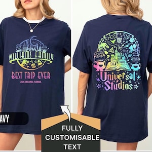 Peut inclure: T-shirt bleu marine avec l'inscription "WILLIAMS FAMILY BEST TRIP EVER 2026 ORLANDO, FLORIDA" sur le devant. Le dos présente un motif coloré "Universal Studios" avec des Minions et d'autres graphiques.