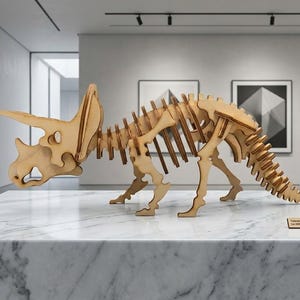 May include: A wooden Triceratops skeleton model displayed on a marble surface. The model is made of light brown wood and features detailed skeletal structures, including horns and a frill. The dinosaur is posed in a walking stance.