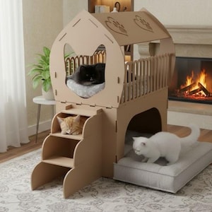 May include: A cardboard cat house with multiple levels, including a sleeping area, steps, and a balcony. A black cat is on the top level, an orange cat on the steps, and a white cat on a bed below. The cat house is in a living room setting.