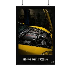 Könnte beinhalten: Ein gelber Sportwagen mit geöffneter Motorhaube, der den Motor freilegt. Der Motorraum ist detailliert mit verschiedenen Komponenten. Der Text unten lautet "427 CUBIC INCHES // 7000 RPM". Das Bild ist ein Posterdruck.