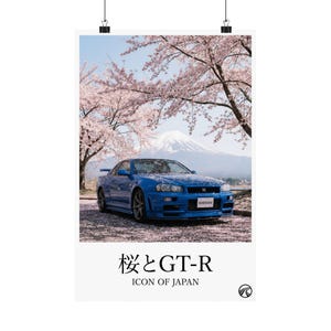 May include: A blue Nissan GT-R sports car is parked beneath cherry blossom trees with Mount Fuji in the background. The poster has the text "桜とGT-R" and "ICON OF JAPAN".