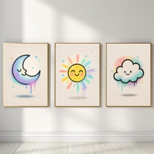Könnte beinhalten: Drei gerahmte Kunstdrucke mit skurrilen Illustrationen zum Thema Wetter. Das Set umfasst einen lächelnden Mond, eine fröhliche Sonne und eine fröhliche Wolke, jeweils mit farbenfrohen Akzenten im Sprühstil und einem hellen Holzmaserungshintergrund.