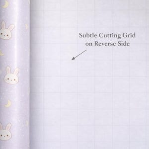 May include: A roll of wrapping paper with a light purple background. The paper is decorated with repeating illustrations of bunny faces and crescent moons. The text "Subtle Cutting Grid on Reverse Side" is visible. The brand name "Before the Ribbon" is also visible.