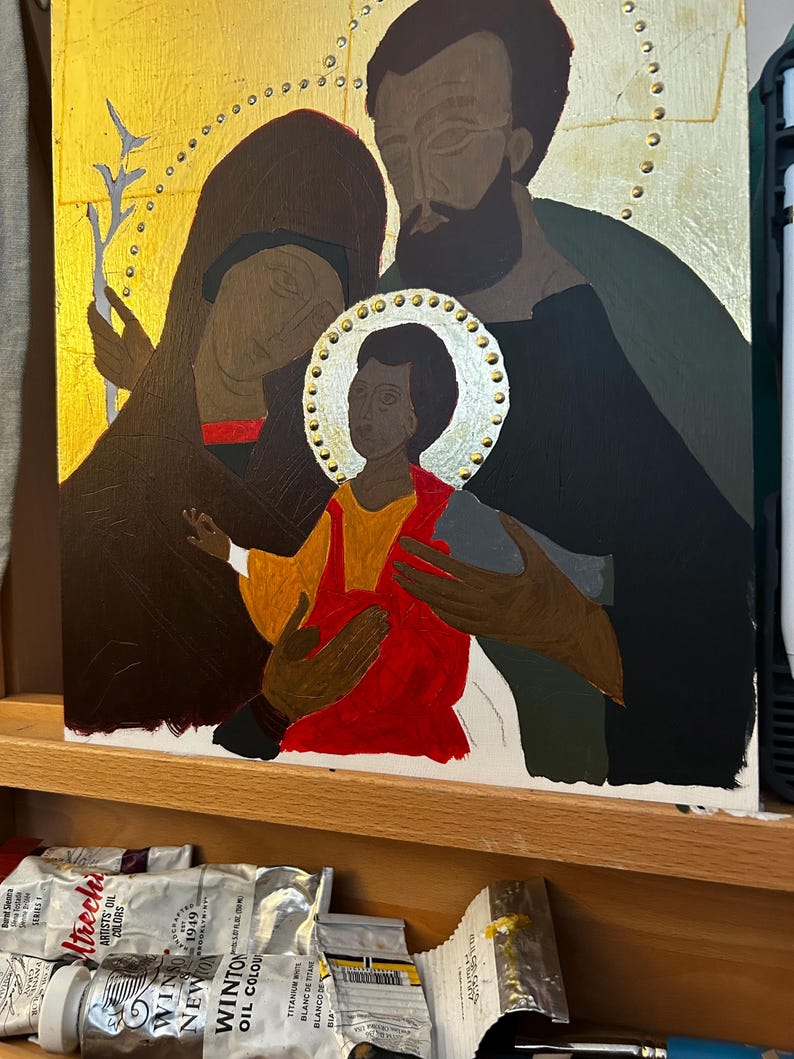 Pu&ograve; includere: Un dipinto religioso su pannello rettangolare che raffigura tre figure con aureole su sfondo dorato. Il bambino centrale indossa una tunica rosso brillante, affiancato da due adulti in abiti scuri. Il bambino tiene in mano un uccellino grigio.