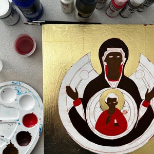 Pu&ograve; includere: Un dipinto quadrato su fondo in foglia d'oro raffigurante una figura stilizzata in abito nero con accenti rossi, che tiene una figura pi&ugrave; piccola in abito rosso con un'aureola dorata, circondato da flaconi di vernice e una tavolozza.