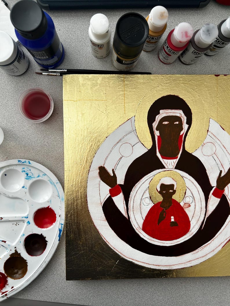Pu&ograve; includere: Un dipinto quadrato su fondo in foglia d'oro raffigurante una figura stilizzata in abito nero con accenti rossi, che tiene una figura pi&ugrave; piccola in abito rosso con un'aureola dorata, circondato da flaconi di vernice e una tavolozza.