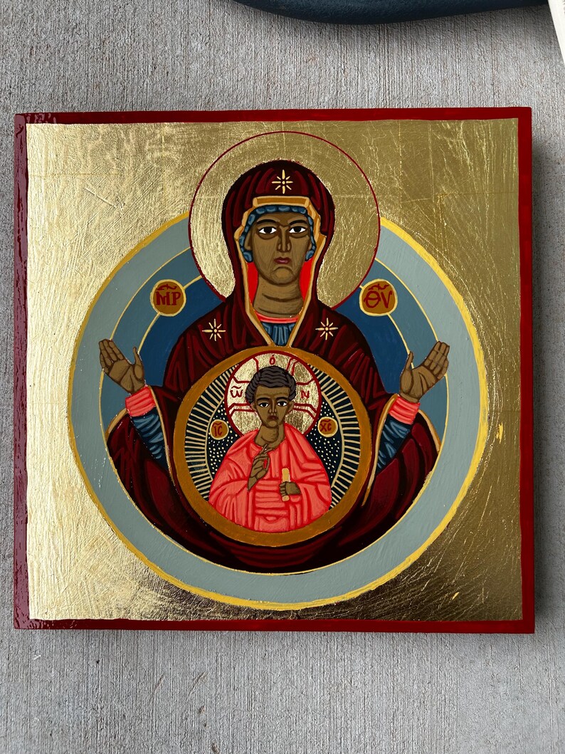 Pu&ograve; includere: Un'icona religiosa quadrata raffigurante una figura centrale in una veste rosso scuro con un'aureola dorata, che tiene una figura pi&ugrave; piccola in una veste rossa all'interno di un medaglione circolare. Lo sfondo &egrave; in foglia d'oro con bordo rosso e lettere greche.