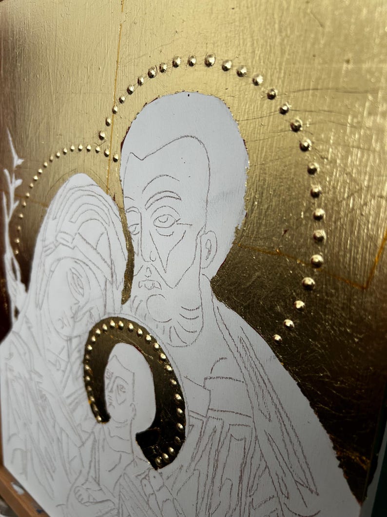 Pu&ograve; includere: Un pannello icona religiosa con sfondo in foglia d'oro e un design a aureola con punti in rilievo. L'opera mostra un disegno a linee di tre figure in stile tradizionale, con una piccola aureola centrale riempita di foglia d'oro e punti.