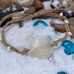 Puede incluir: Una taza de cerámica blanca con un asa negra y el texto "But First, Coffee" en negro, con una fuente de estilo manuscrito. La taza está sobre una superficie blanca.