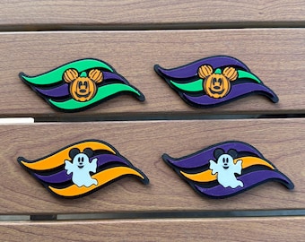 May include: Four decorative rubber charms featuring wave-shaped backgrounds. Two charms display an orange Mickey Mouse-shaped pumpkin, while two display a white ghost. The designs incorporate vibrant green, purple, orange, and black color accents.