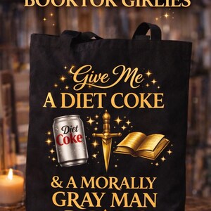 May include: Black tote bag with the text "FOR THE BOOKTOK GIRLIES" and "Give Me A DIET COKE & A MORALLY GRAY MAN." The design includes a Diet Coke can, a sword, and a book.