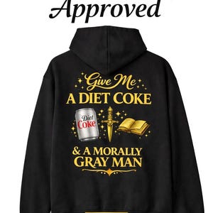 May include: Black hoodie with the text "Give Me A Diet Coke & A Morally Gray Man." The design includes a Diet Coke can, a sword, and a book. The words "Reader Girl Approved" are at the top.