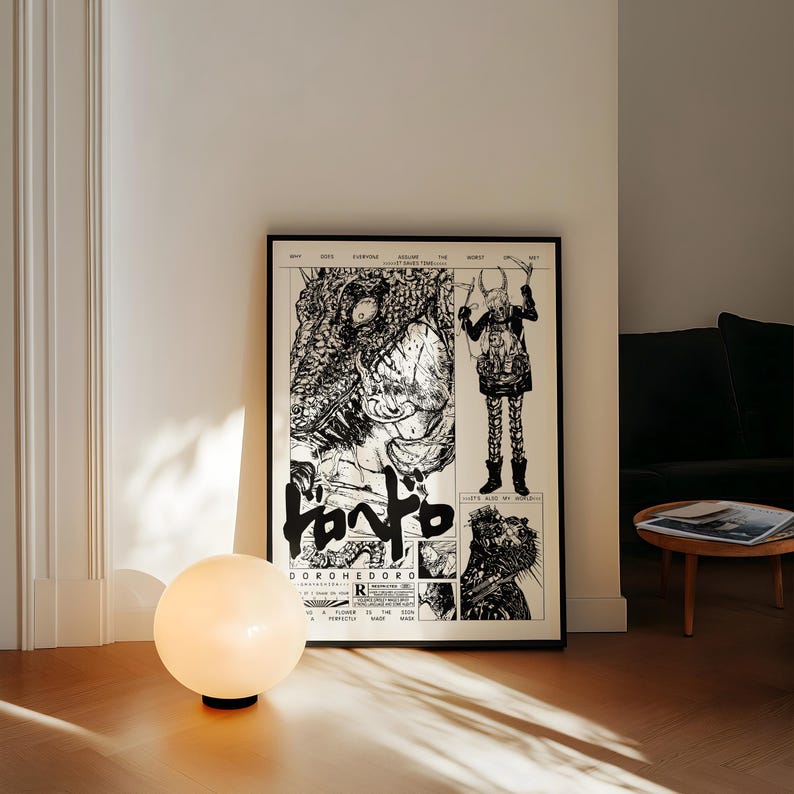 May include: A framed black and white comic book style poster with Japanese text and illustrations. A round, white globe lamp sits on the floor in front of the poster. The poster is leaning against a white wall.
