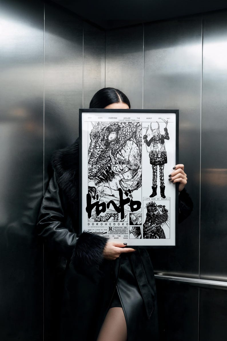 May include: A framed black and white artwork with manga illustrations and Japanese text. The artwork, titled "Dorohedoro", is held in front of a person. The frame is black. The artwork is displayed in a lift.