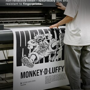 May include: A black and white poster with the text "MONKEY-D-LUFFY" and "$3.000.000.000. MARINE". The poster is printed on premium matte paper, 200 gsm stock. The poster features a detailed illustration of a character.