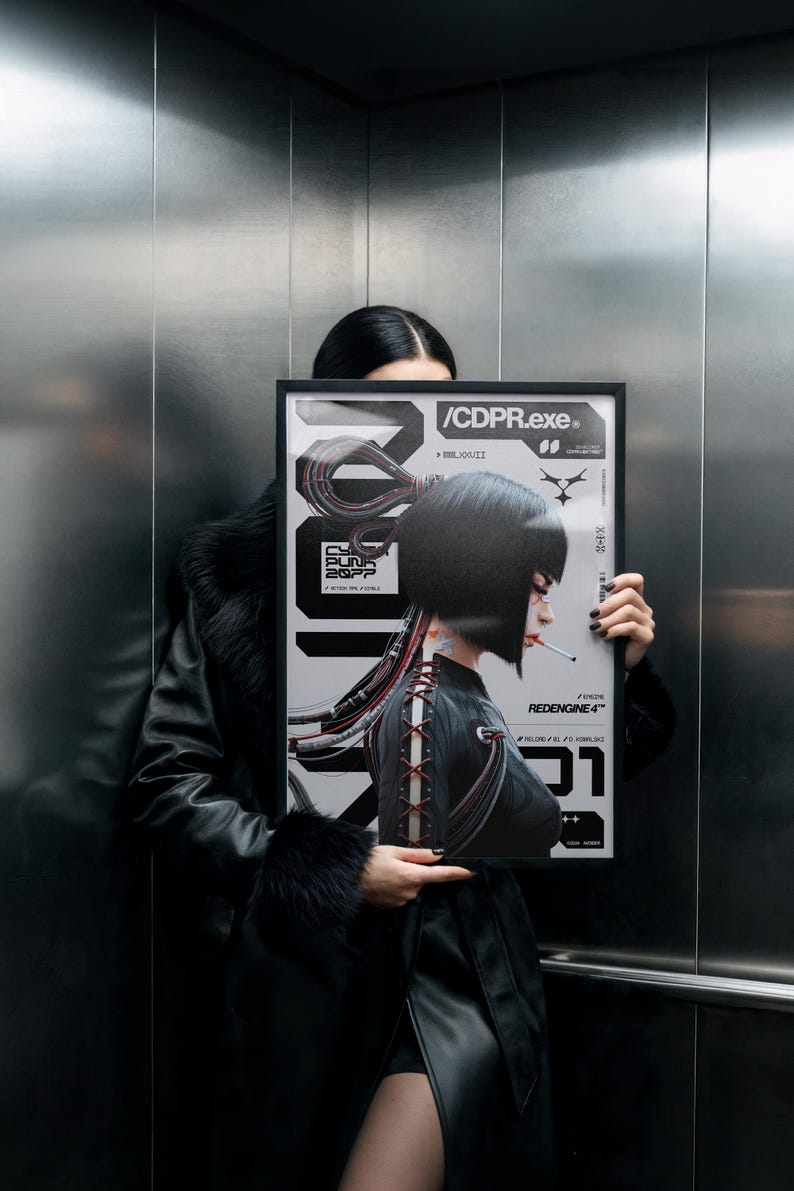 Op de afbeelding: Een ingelijste poster met een cyberpunk-thema. De poster toont een vrouw met kort zwart haar, een sigaret en een gedetailleerd ontwerp met de tekst "/CDPR.exe" en "REDENGINE 4". Het kleurenpalet is voornamelijk zwart, wit en rood.