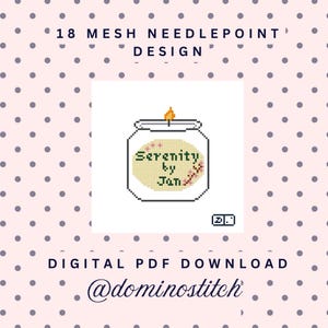 May include: A digital needlepoint pattern featuring a pixelated candle in a glass jar with the text Serenity by Jan on a beige label. The design includes a small orange flame and a floral accent. The background is light pink with dark polka dots.